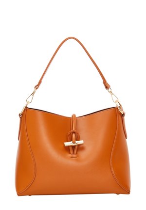 Sac à main en cuir camel avec une bandoulière simple, fermeture par fermoir doré et design lisse et courbé sur fond blanc.