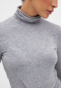 Grå polotröja i ett mjukt, texturerat tyg. Har en figursydd design och ribbad krage, lämplig för lager-på-lager.