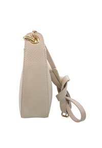 Borsa a tracolla in pelle beige con texture, vista di lato, che presenta un anello in metallo dorato e una tracolla regolabile fissata accanto.