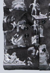 Schwarzes Hemd mit Knöpfen, das eine Collage aus klassischen Skulpturen in Graustufen zeigt, mit kontrastierenden schwarzen Knöpfen und einem strukturierten Stoff.