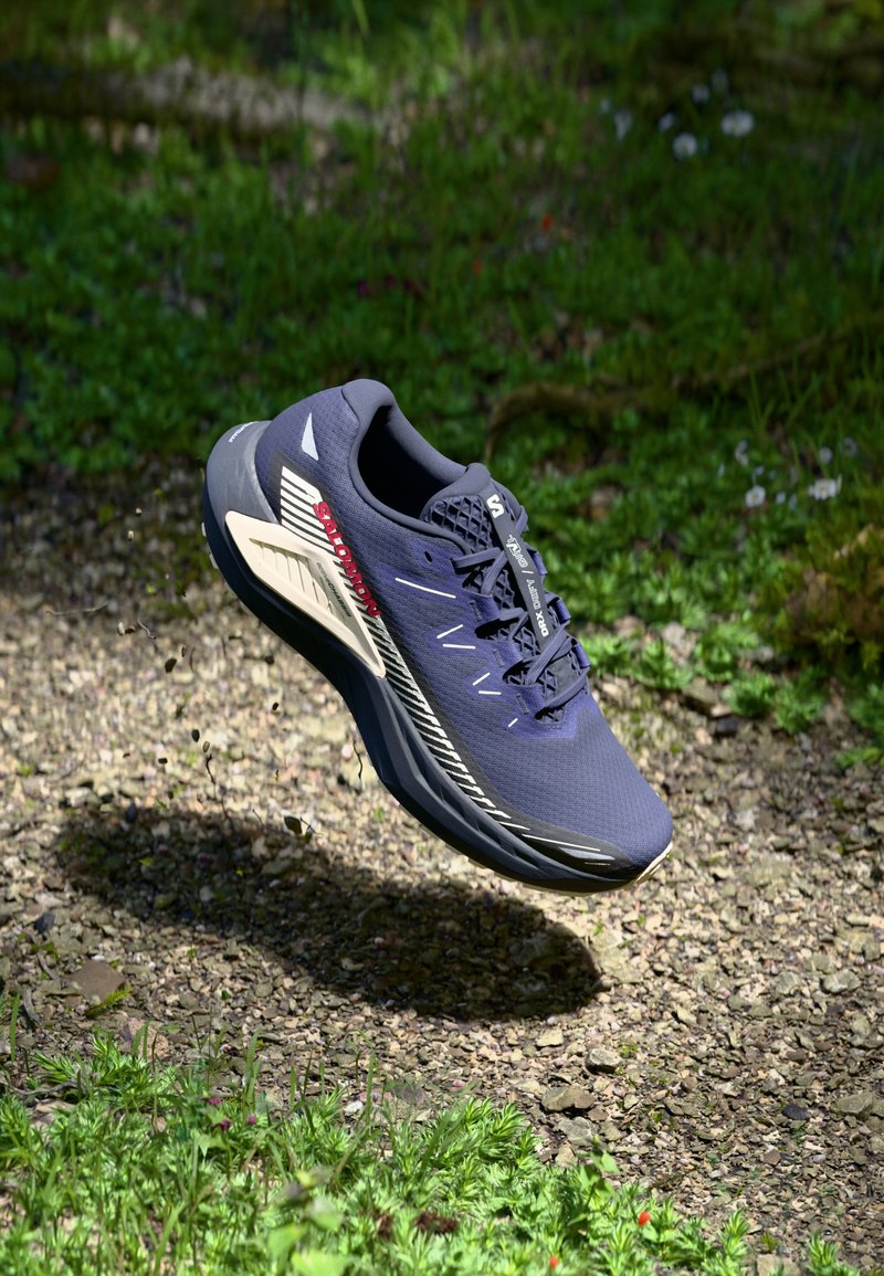 Herrenschuh zum Laufen mit einem obermaterial aus navyfarbenem Netzgewebe, weißen Akzenten und einer gepolsterten Sohle. Verfügt über eine strukturierte Oberfläche und eine verstärkte Zehenbox.