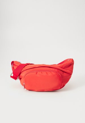 Sac banane rouge vif avec sangle réglable et poche avant zippée sur fond blanc uni.