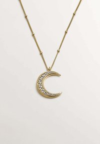 Collar de colgante de oro con un diseño de luna creciente adornado con piedras preciosas transparentes a lo largo de un borde. La cadena incluye pequeños acentos redondos.