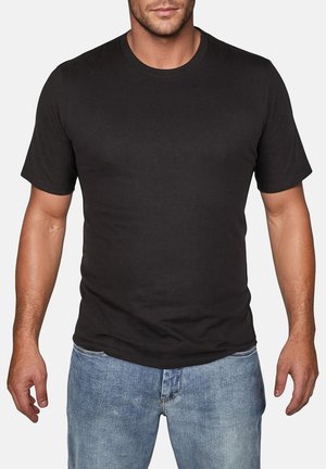 T-shirt en coton noir à manches courtes et col rond, avec une coupe ajustée et une texture lisse, associé à un jean bleu clair.
