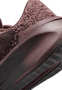 Burgundowe buty sportowe z textured knit górą, eleganckim designem, wyściełanym zapiętkiem oraz gumową podeszwą z falistym wzorem dla lepszej przyczepności.