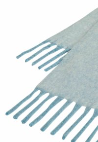 Lichtblauwe sjaal met een zachte, gestructureerde stof en geknoopte franjes aan de randen. Het materiaal oogt licht en soepel.