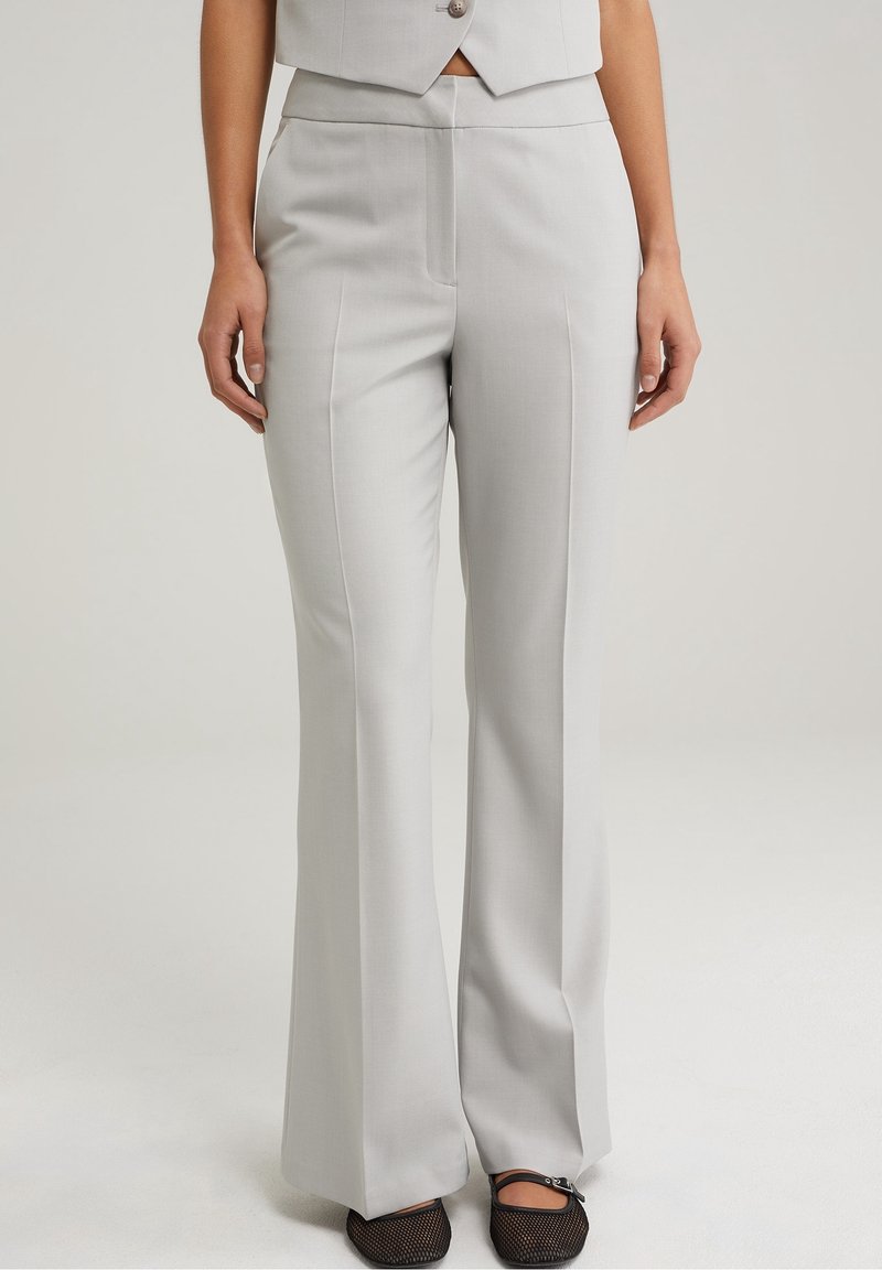 Light gray tailored trousers with a straight-leg fit, featuring front pleats and a mid-rise waistband. Texture appears smooth and fabric is sleek.
