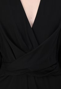 Mustikkapinkki wrap-mekko, jossa on syvä V-pääntie, pehmeä kangas ja laskeutuvat yksityiskohdat, sekä tarkasti määritelty vyötärö. Keskity eleganceen ja yksinkertaisuuteen.