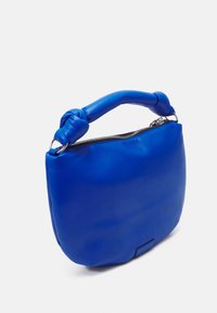 Borsa in vera pelle blu con una forma arrotondata, manico annodato e chiusura a zip argentata. Texture liscia con hardware e dettagli minimali.