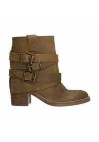 Bottine en suede marron avec plusieurs détails de sangles et des boucles en métal. Dotée d'un talon carré et d'une fermeture éclair latérale pour un enfilage facile.