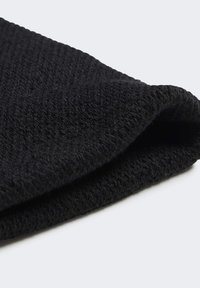 Crni pleteni beanie s teksturiranim završetkom, koji se ističe preklopljenim rubom i mekanim, fleksibilnim materijalom. Jednostavni dizajn bez vidljivih logotipa ili uzoraka.
