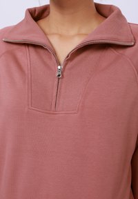 Glidlås genser i støvete rose, med ribbet krage, kvart-lengde glidelås og glatt stoff med en teksturert yoke panel.