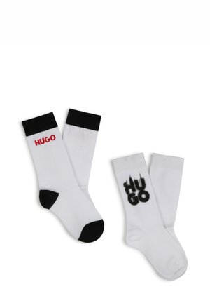 White ankle socks with black accents; features red and black "HUGO" branding; cotton material with ribbed cuffs for comfort.