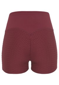 Bordeauxfarbene Shorts mit hohem Bund, im unteren Teil mit einem strukturierten Muster und oberhalb aus glattem Stoff, sichtbare Nahtakzente.