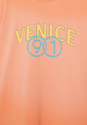 Texte jaune « VENICE » au-dessus de deux cercles bleus superposés composés de points contenant les chiffres « 9 » et « 1 » sur un fond en tissu couleur pêche.
