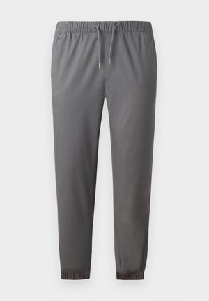 Grå joggebukser laget av mykt stoff, med elastisk midje med snor, smale ankler og en glatt tekstur.