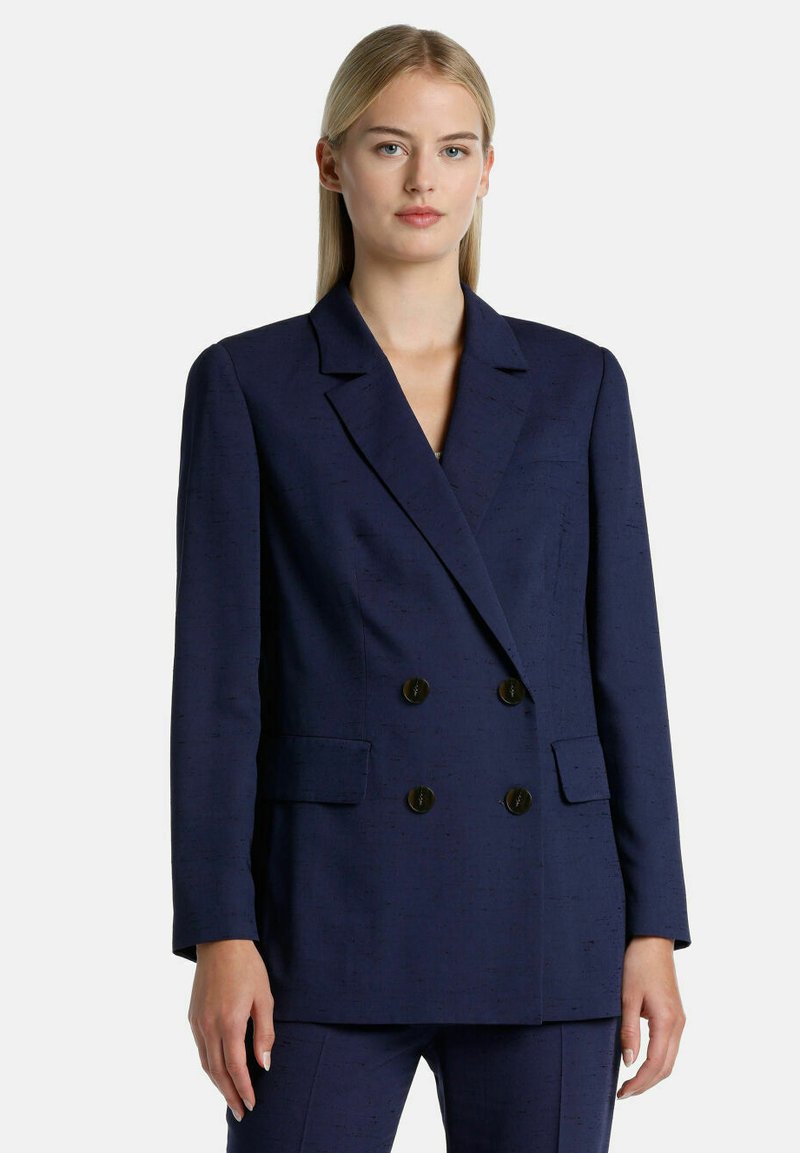 Navy blue double-breasted blazer in textured fabric with wide peak lapels, two front pockets, and black round buttons.