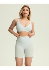 Jasnoniebieski biustonosz z elastycznej tkaniny oraz szorty z wysokim stanem z delikatnymi detalami szycia i gładką fakturą, oferujące bezszwowy wygląd.