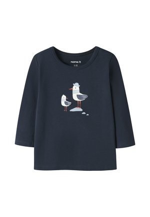 Camiseta de manga larga para niño pequeño en azul marino con dos gaviotas, una de ellas con un sombrero gris, situadas sobre pequeñas piedras en el centro.