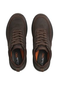 Zapatos de cuero marrón con cordones, que cuentan con una puntera redondeada, detalles perforados, cordones marrones y plantillas naranjas, todo sobre una suela de goma negra.