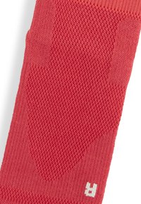 Calzino rosso lavorato a maglia con un motivo testurizzato, caratterizzato da un'area liscia e un accento di logo bianco sul polsino.