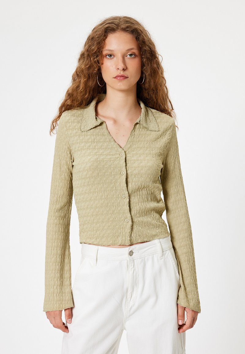 Lichtgroene, gestructureerde button-up shirt met een kraag en lange mouwen, met een cropped lengte en subtiel golfpatroon.