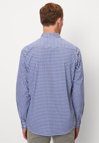 Blauw en wit geruite shirt met lange mouwen en knoopmanchetten. Heeft een klassieke kraag en een gebogen zoom. Lichtgewicht stof.