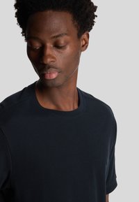 T-shirt blu navy a maniche corte con scollo rotondo, realizzato in un tessuto morbido, con una superficie testurizzata e una vestibilità comoda.