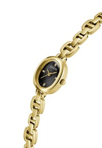 Montre ovale en or avec un cadran noir et un bracelet en maillons dorés, arborant un logo et des index horaires décoratifs. Design élégant et stylé.