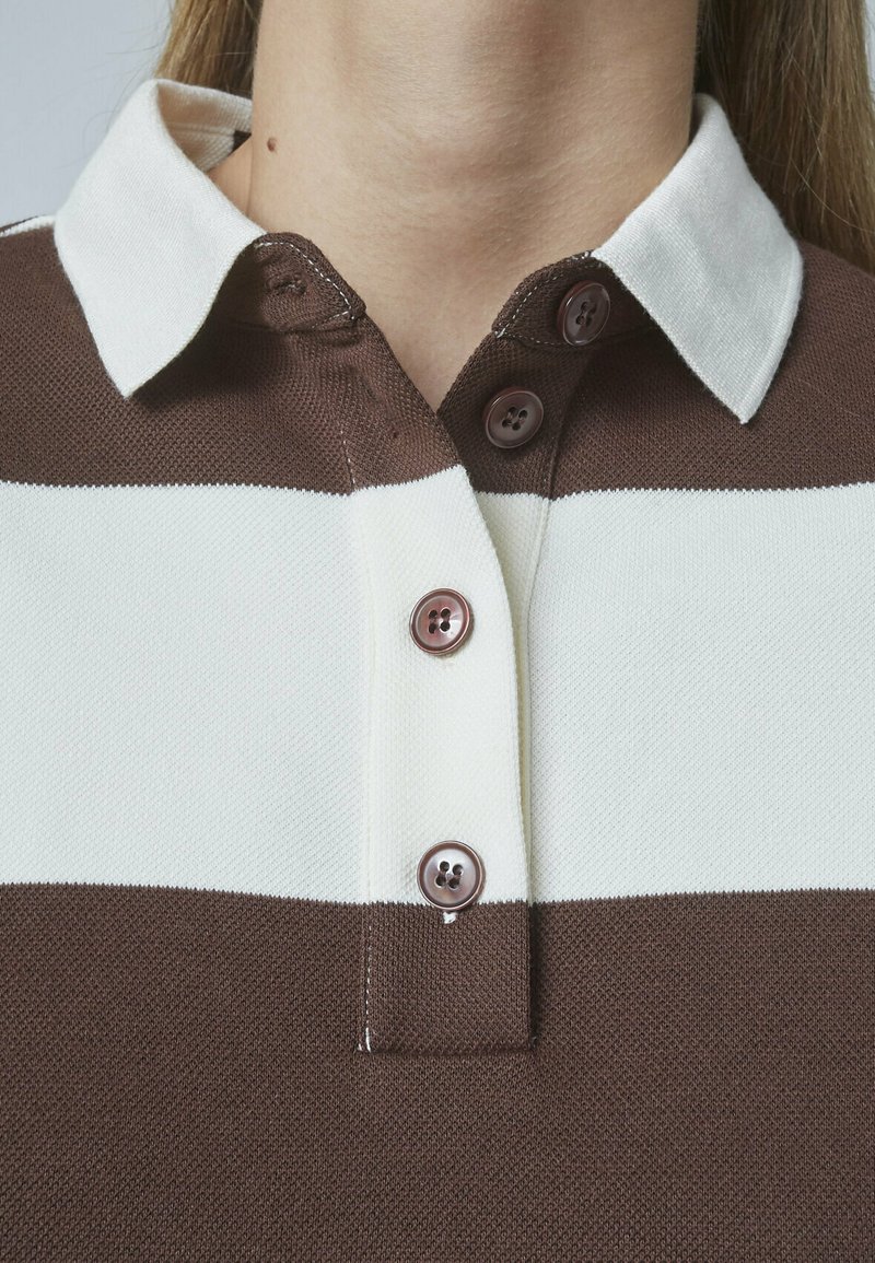 Brun og hvid stribet polo shirt med krave, der har tre brune knapper og et tekstureret stof.