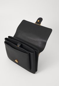 Zwarte leren tas met een gestructureerde afwerking, gouden hardware, een opklapbaar ontwerp en meerdere interieurcompartimenten voor organisatie.