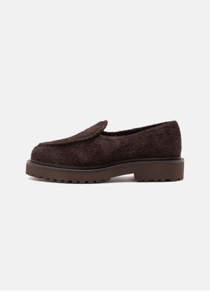 Mocassin marron foncé texturé avec semelle épaisse et petit talon, vu de profil sur un fond clair uni.