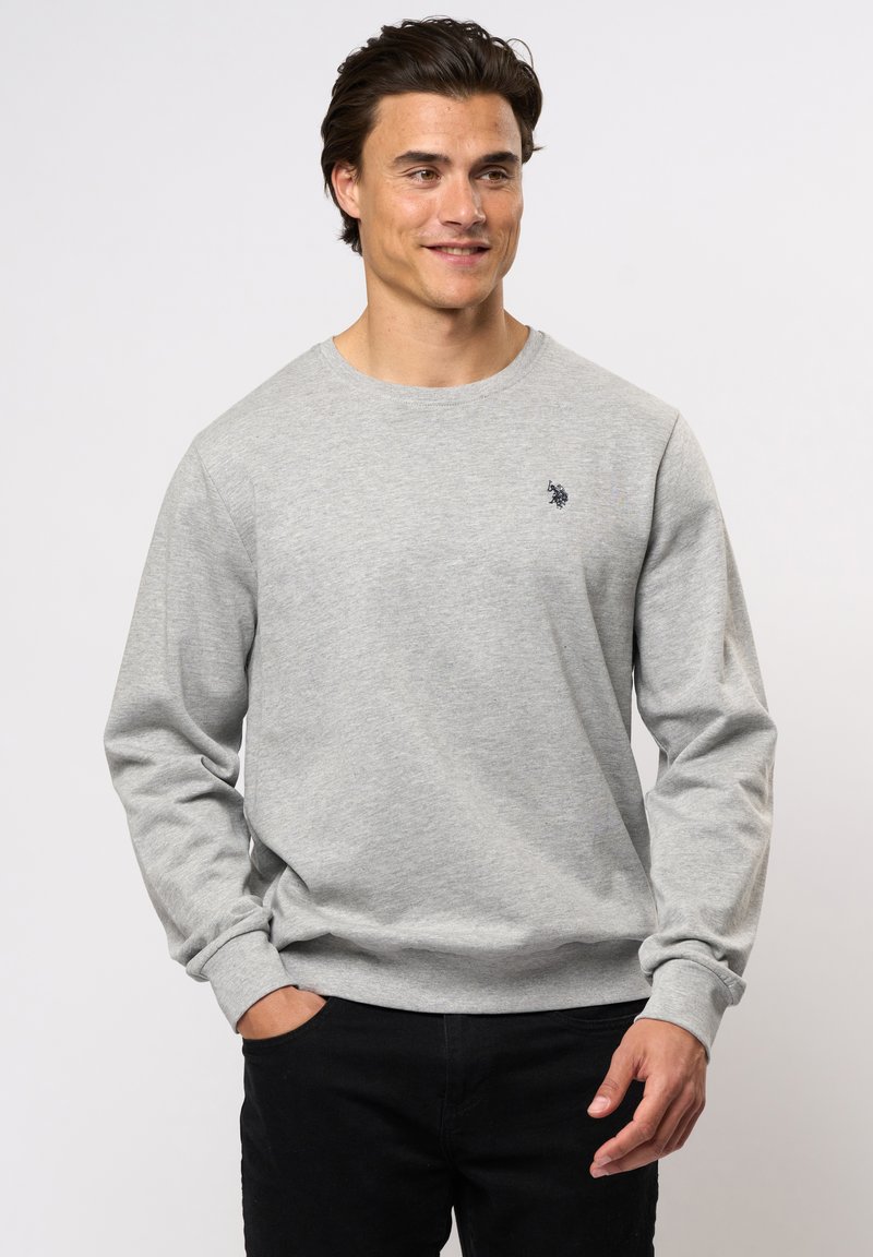 Grijze sweatshirt van een katoenmix met lange mouwen, ronde hals en een klein donker logo op de borst, gecombineerd met zwarte broek.