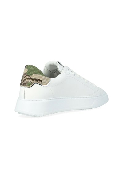Witte lage sneaker met dikke zool en groene camouflage hiel tab, gezien vanaf de achterzijde op een witte achtergrond.