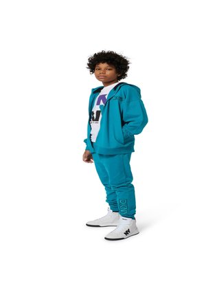 Un hoodie turquoise assorti avec un pantalon de jogging, un t-shirt graphique blanc et des baskets montantes blanches avec des accents noirs.