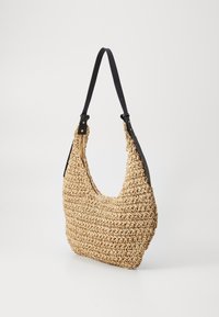 Torbę hobo z plecionego słomy o zaokrąglonym kształcie, w kolorze beżowym, o teksturowanej powierzchni z czarnymi skórzanymi uchwytami i złotymi akcentami.