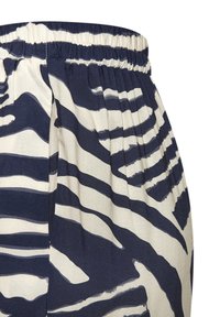Elastic-waist skirt in cream fabric with navy zebra stripes. Features pleats and a textured finish, highlighting the bold pattern.