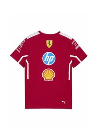 Sarkans kokvilnas T-krekls ar apaļu kaklu, īsām piedurknēm un baltām akcentiem. Aizmugurē attēloti Ferrari, HP un Shell logo.