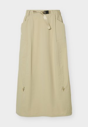 Jupe longue beige avec taille élastique, ceinture beige ajustable avec boucle, grandes poches latérales et deux détails de fermeture éclair près du bas.