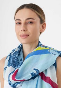 Écharpe légère, de couleur bleue, ornée de motifs graphiques en bleu foncé, rouge et jaune. Texture douce avec un design fluide.