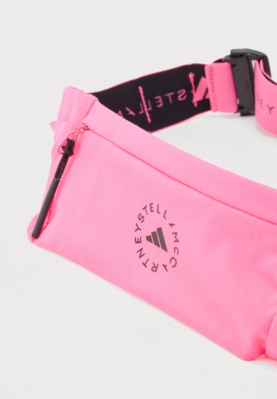 Φούξια τσαντάκι μέσης με τσέπη με φερμουάρ, ρυθμιζόμενο μαύρο λουρί με ροζ λογότυπο και κυκλικό σήμα στο μπροστινό μέρος.