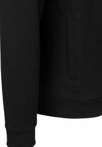 Zwarte sweatshirt met lange mouwen, geribde manchetten en een zijzak die in de naad is geïntegreerd. Gemaakt van een zachte katoenen stof.