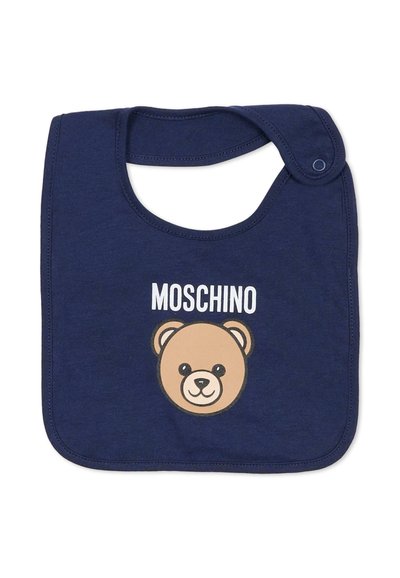 Bavetta in cotone blu navy con grafica di un orso e scritta "MOSCHINO" in bianco. Sagoma arrotondata con chiusura a scatto sul collo. Tessuto morbido.