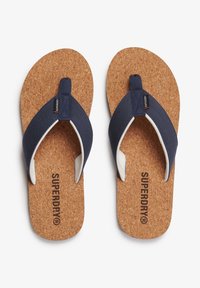 Granatowe klapki z korkową wkładką, materiałowymi paskami i białymi akcentami. Posiadają nadrukowane na wkładce logo "SUPERDRY".