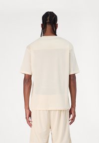 New Era Marškinėliai su spaudiniu - beige