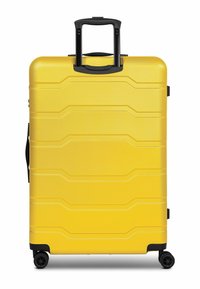 Maleta rígida amarilla con superficie texturizada, acentos negros, asa retráctil y cuatro ruedas para una fácil maniobrabilidad.