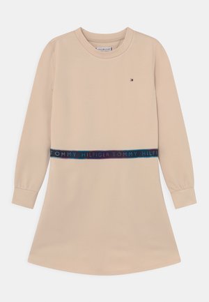 Beżowa sukienka z długim rękawem, okrągłym dekoltem i elastycznym paskiem z logo "Tommy Hilfiger", małe logo na piersi.
