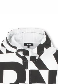 Zwart-witte zip-up hoodie met een gedurfde logopatroon, voorzien van een aansluitende capuchon en elastische afwerking. Gemaakt van zachte stof met een gladde textuur.