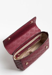 Burgundy syntetisk lædertaske med præget blomsterdesign, magnetisk lukning og cremefarvet indre foring med en lynlåslomme og kortpladser.