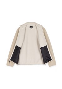 Veste beige clair avec un extérieur en polaire texturée, un intérieur lisse et des accents en maille noire sur les côtés. Fermeture zippée et sans capuche.
